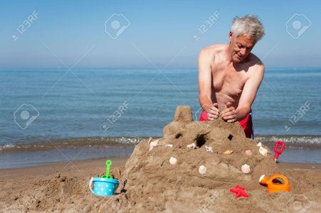 6087235-Uomo-anziano-la-costruzione-di-un-castello-di-sabbia-sulla-spiaggia-con-i-giocattoli-in-.jpg